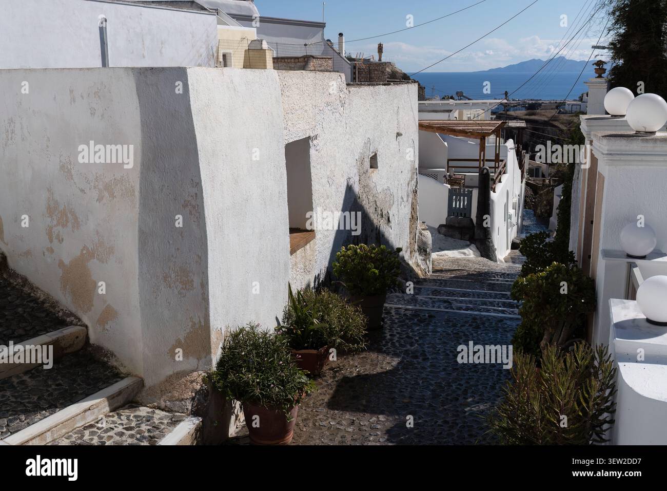 La scalinata acciottolata si snoda attraverso edifici imbiancati a Santorini, in Grecia. Foto Stock