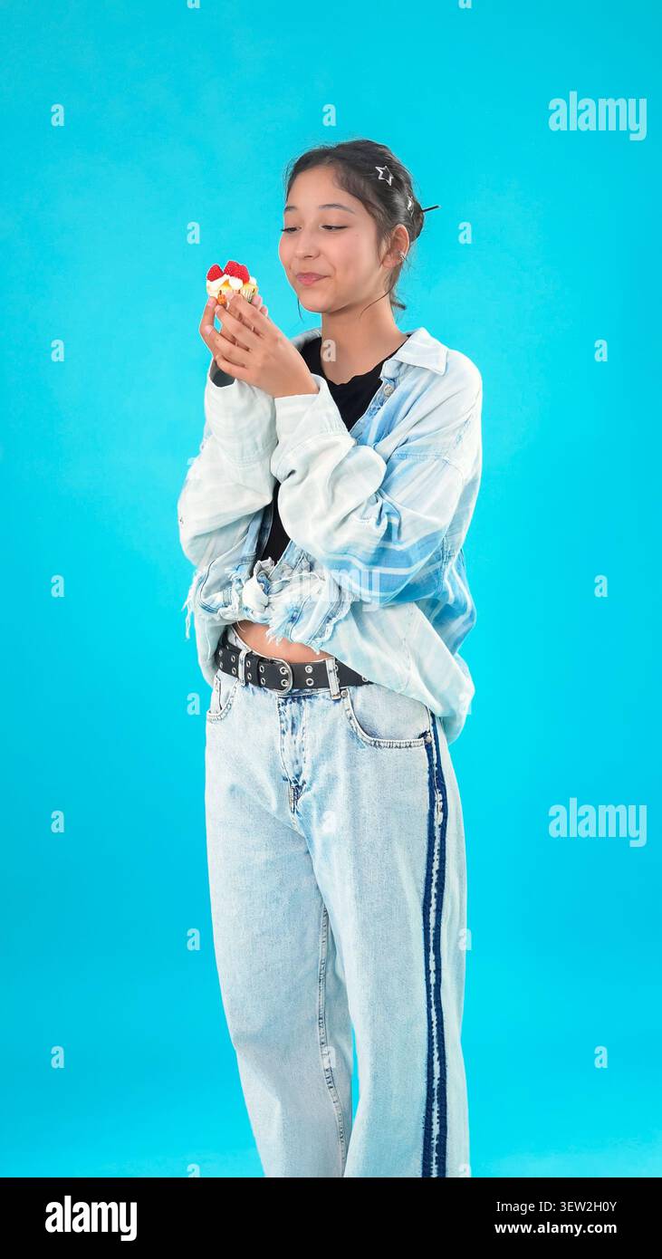 Giovane donna che tiene in mano una tazza e ha un aspetto premuroso mentre fa una breve pausa Foto Stock