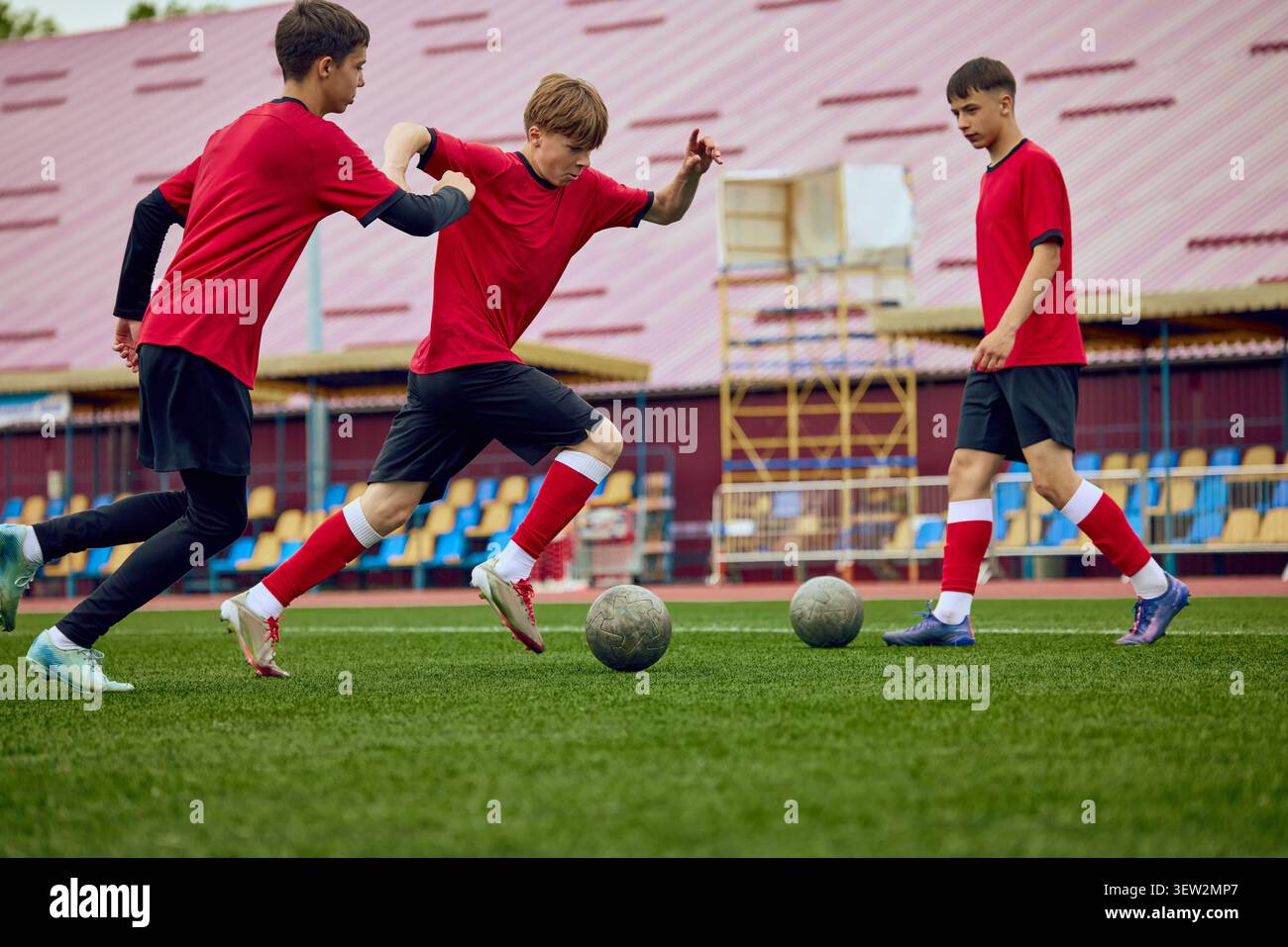 Giocatori di calcio giovanili che praticano dribbling sul campo. Foto Stock