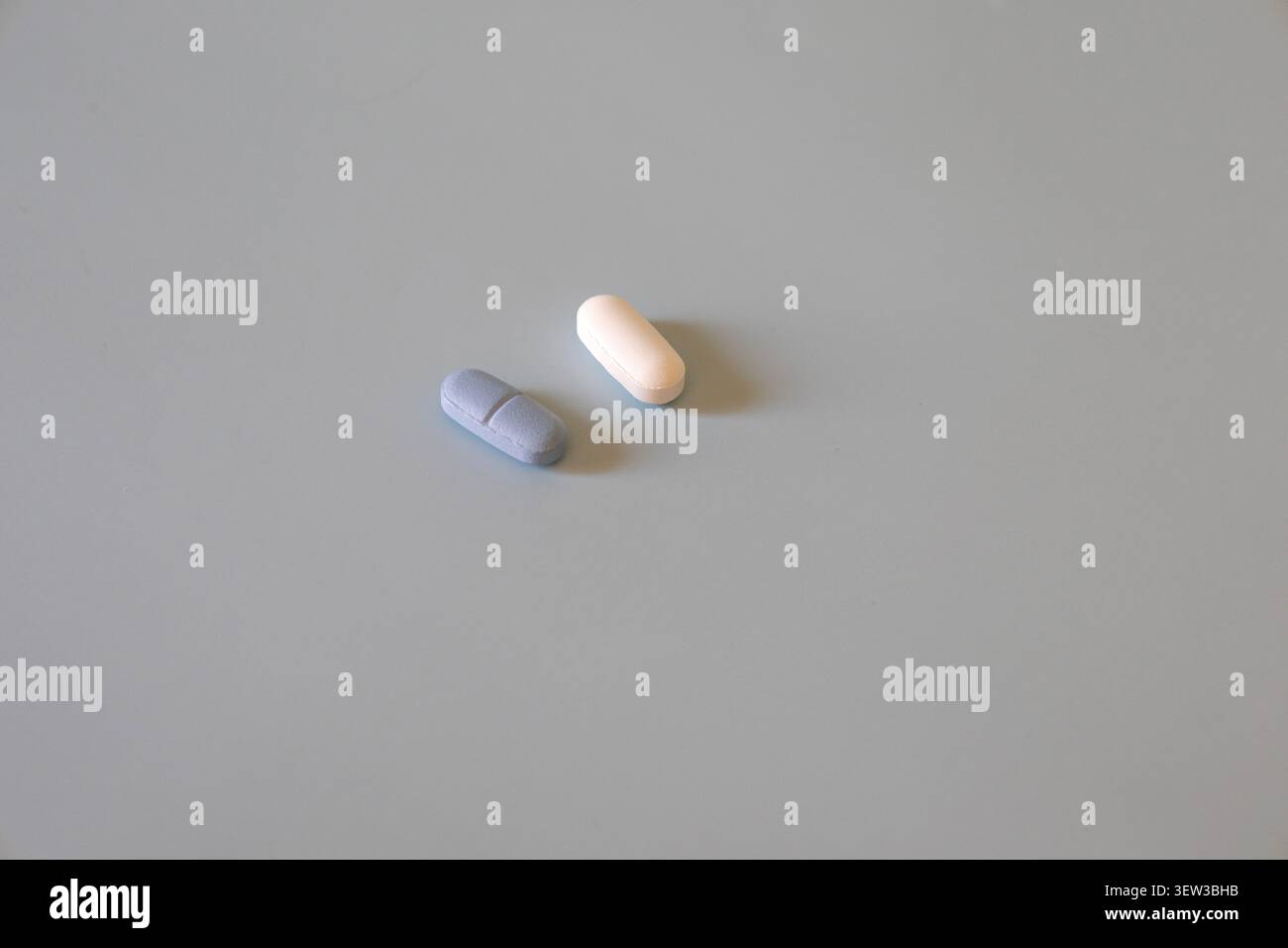 Capsule blu e bianche sulla superficie del tavolo leggero Foto Stock