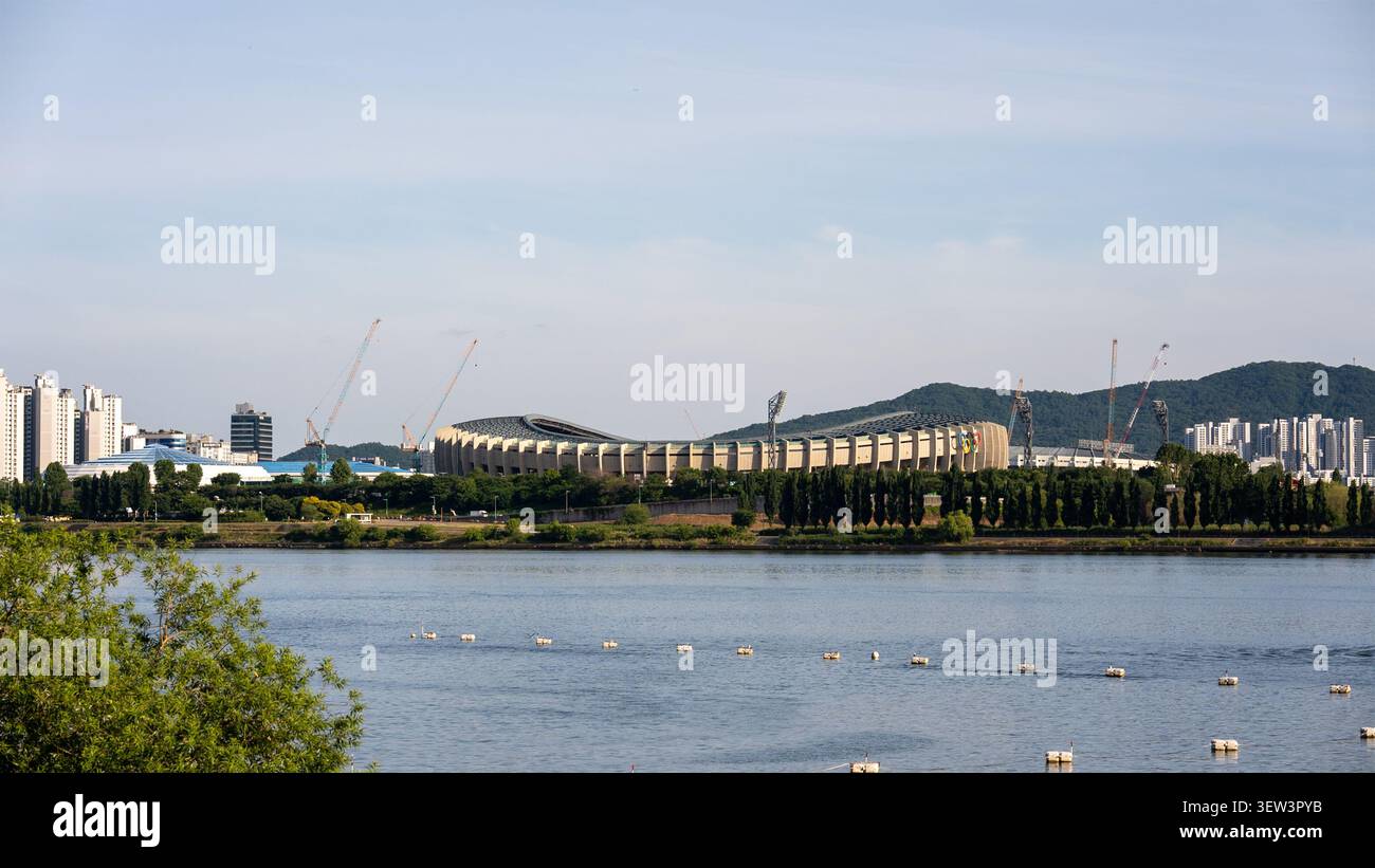 Una chiara vista diurna del complesso sportivo di Jamsil attraverso il fiume Han, catturata dalla riva al Ttukseom Hangang Park a Seoul. Foto Stock