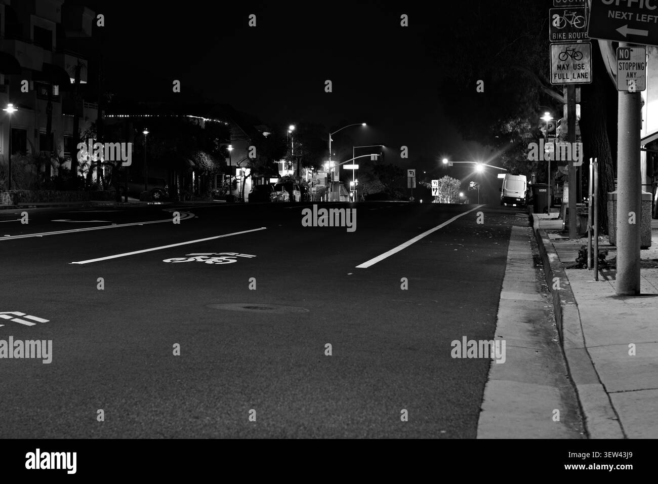 Tranquilla Newport Beach Street con cartello a senso unico, segnaletica per le biciclette e vetrine notturne. Foto Stock
