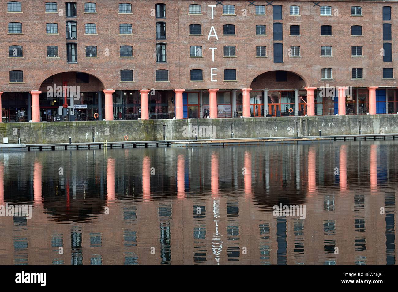 Liverpool, Merseyside, Inghilterra, Regno Unito - 19 marzo 2020: Edificio Tate Liverpool presso il Royal Albert Dock che si riflette nelle calme acque del bacino. Foto Stock