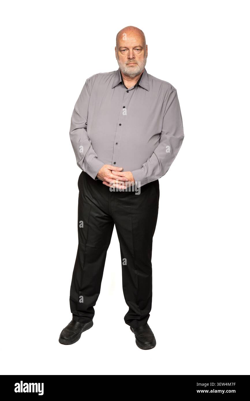 Ritratto a tutta lunghezza di un uomo serio di 55 anni con camicia grigia e pantaloni neri Foto Stock