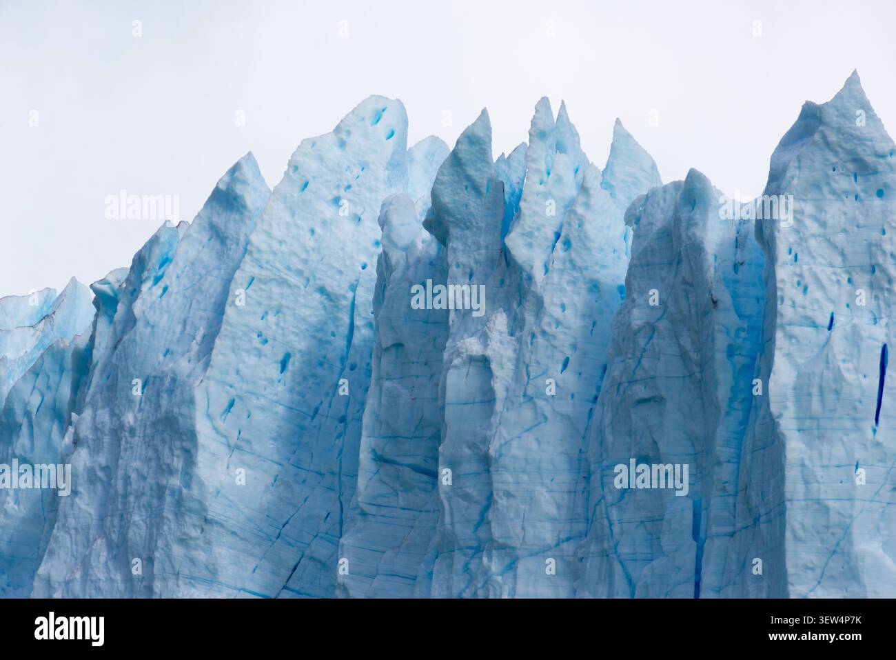 Primo piano di un'impressionante parete del ghiacciaio, caratterizzata da formazioni di ghiaccio affilate e un'atmosfera rilassante e potente Foto Stock