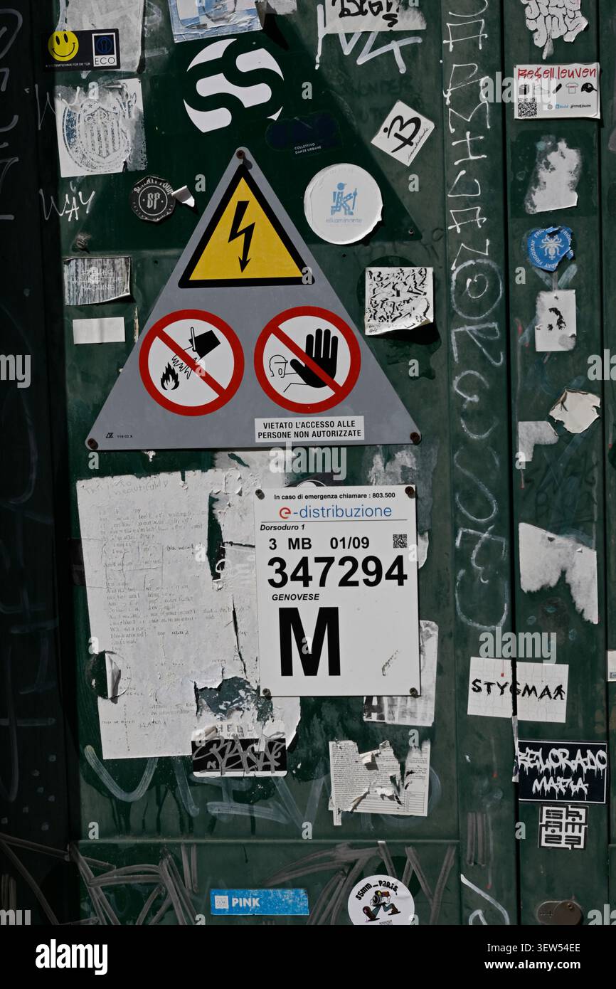Adesivi e poster incollati su una parete a Venezia, Italia. Foto Stock