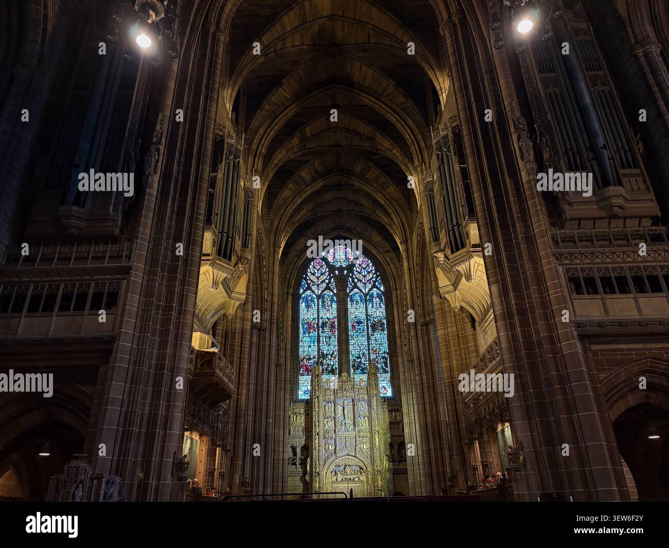 Interno della cattedrale di Liverpool, Liverpool. Architettura neogotica caratterizzata da torreggianti archi in pietra e vetrate colorate illuminate. Foto Stock