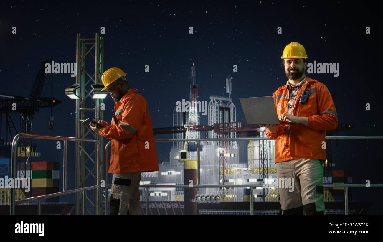 Ritratto di un ingegnere di piattaforme offshore sorridente che gestisce le risorse durante la crisi petrolifera utilizzando un laptop. Lavoratore felice che rivede le metriche di estrazione durante il blocco marittimo che influisce sulle operazioni, telecamera A. Foto Stock