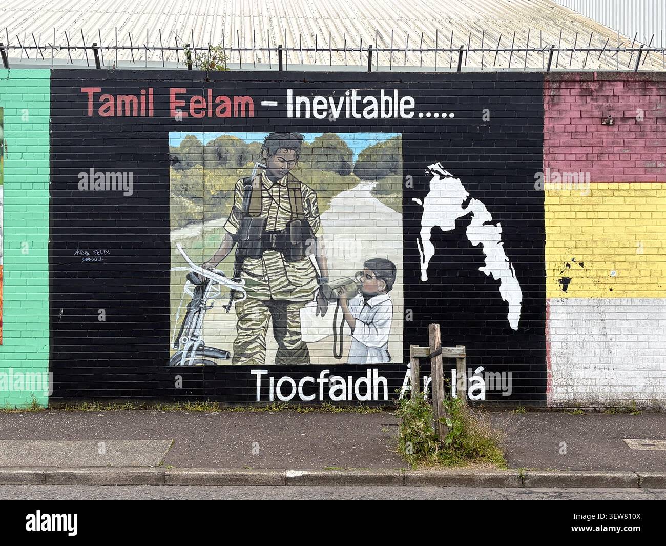 Murale politico su un muro della pace a Belfast, Regno Unito. Il murale mostra un combattente, un bambino, e la mappa di Tamil Eelam con testo irlandese. Foto Stock