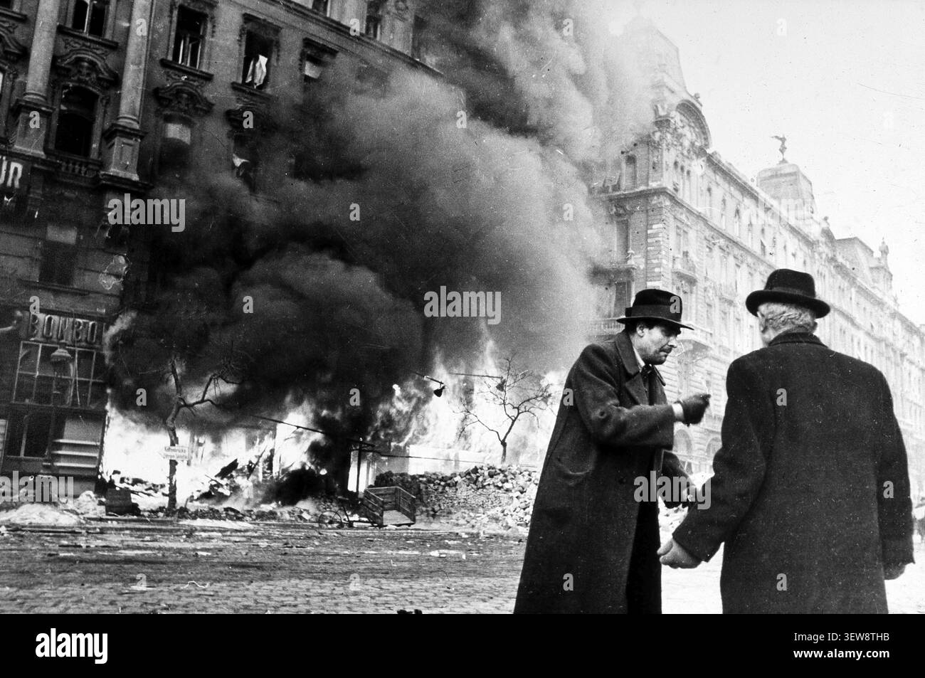 Due uomini combattono a Budapest per la strada di una casa in fiamme, Budapest, Ungheria, 1945 seconda guerra mondiale, liberazione di Budapest. La battaglia di Budapest la Foto Stock