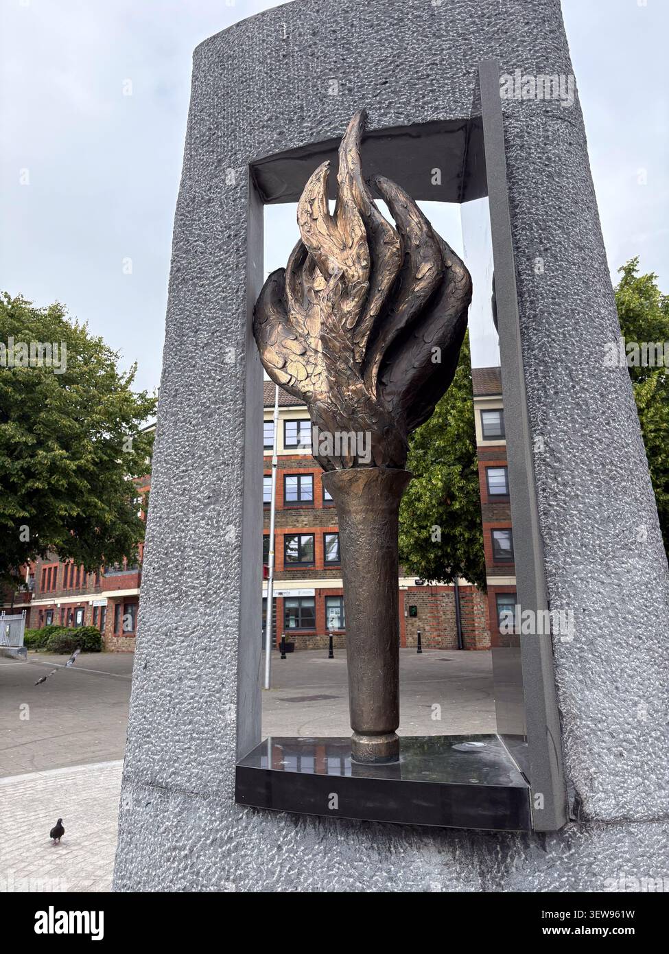 Una scultura di torcia in bronzo all'interno di una cornice in pietra al memoriale delle vittime della dipendenza da eroina a Dublino, Irlanda. Foto Stock