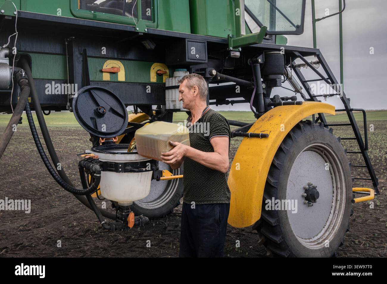 Riempimento del serbatoio di un'irroratrice semovente prima dell'irrorazione del prodotto. Immagine che illustra la preparazione delle attrezzature agricole e la gestione della protez. Prodotto Foto Stock