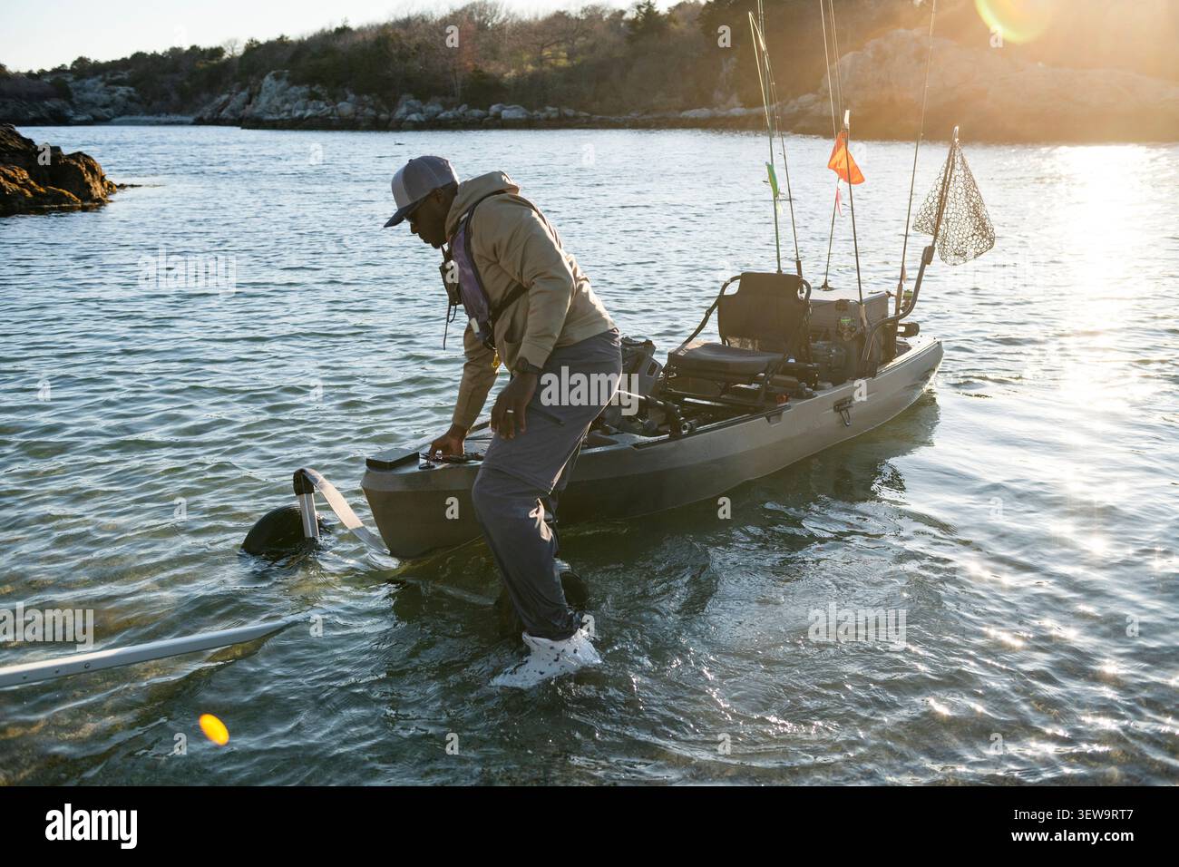 Uomo che lancia il suo kayak da pesca completamente equipaggiato Foto Stock