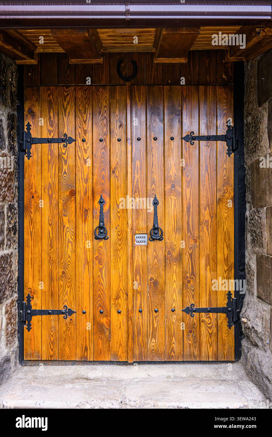 Doppi sportelli in legno con cerniere e maniglie in ferro nero Foto Stock