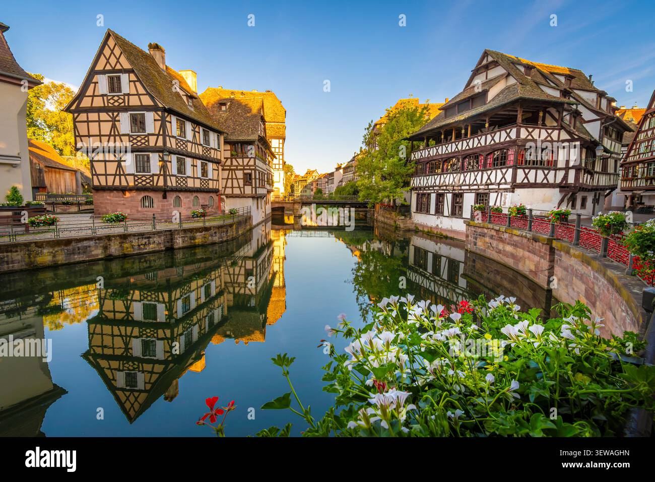 Facciate delle tradizionali case in legno lungo il fiume Ill nel pittoresco e turistico quartiere Petite France di Strasburgo, Francia Foto Stock