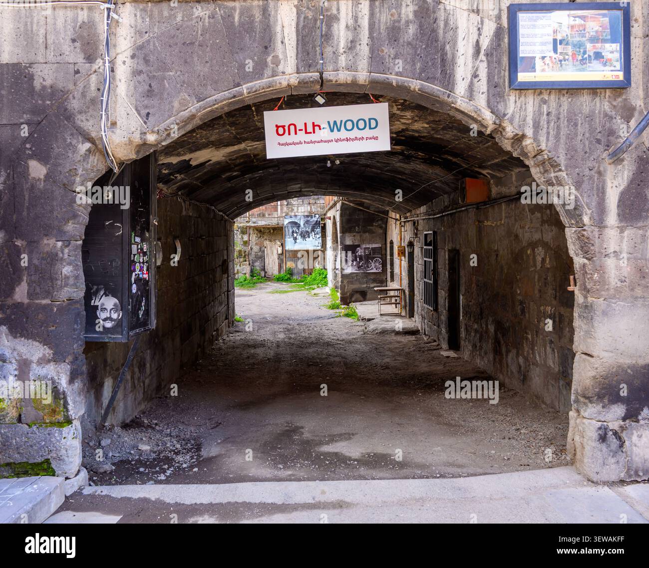 Una vecchia arcata in pietra conduce al tunnel abbandonato. Il percorso della sporcizia si estende all'interno oscuro Foto Stock
