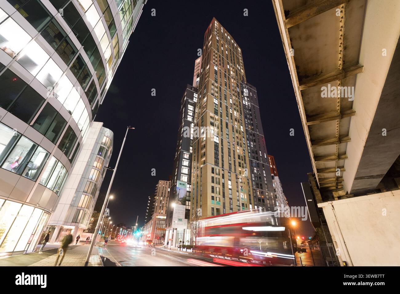 Un autobus di Londra passa davanti alla torre Nine Elms Point di notte, evidenziando il rapido sviluppo urbano nell'area Nine Elms/Vauxhall. Foto Stock