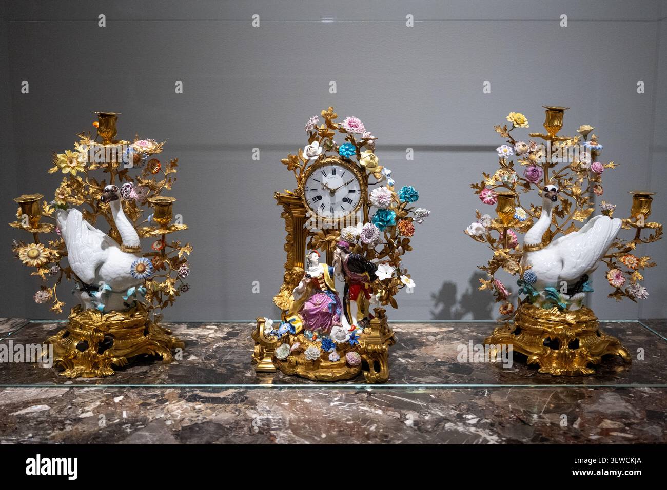 Amsterdam, Paesi Bassi - 15 aprile 25: Orologio decorato con figure in porcellana, rami floreali e motivi a cigno, esposto in una cassa del Rijksmuseum in A. Foto Stock