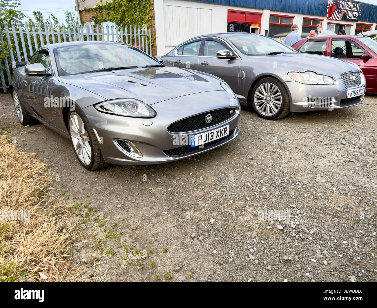 Vetture Jaguar XKR e Jaguar XF grigie parcheggiate all'esterno del Willie's American Diner Foto Stock