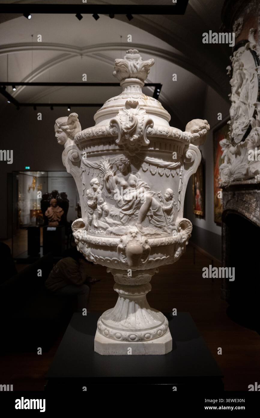 Amsterdam, Paesi Bassi - 15 aprile 25: Urna decorativa in marmo bianco con figure a rilievo classiche esposte in una galleria del Rijksmuseum, Amsterdam, Netherlan Foto Stock