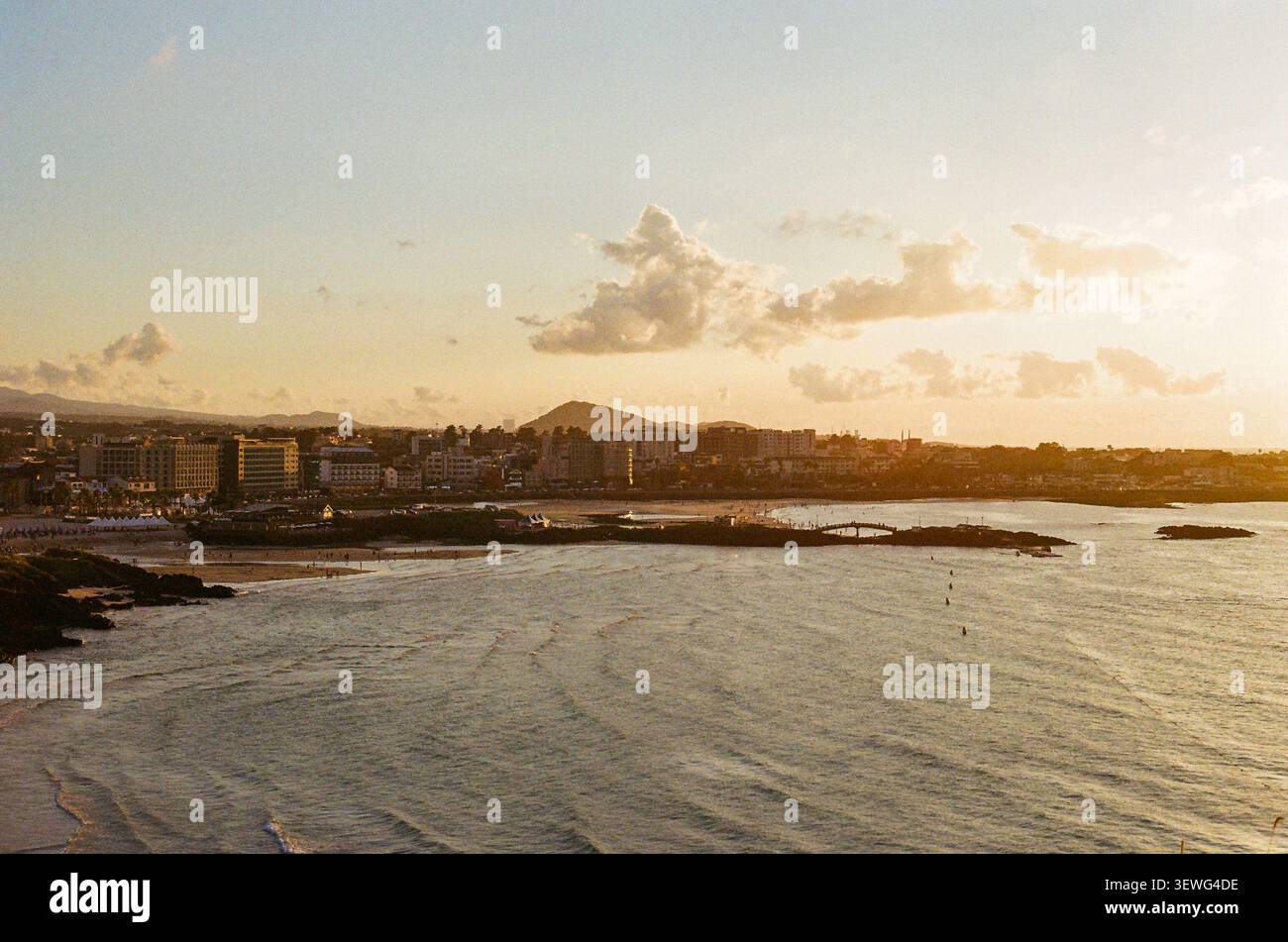 Tramonto sulla baia costiera e sulle onde oceaniche Foto Stock