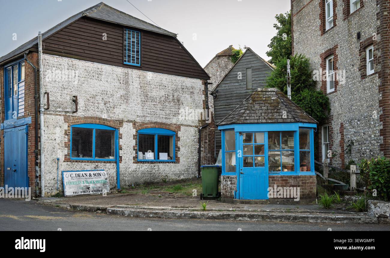 Resti della vecchia stazione di servizio di Rodmell, East Sussex. Con i vecchi fattorini e l'edificio del fabbro a lato. Foto Stock