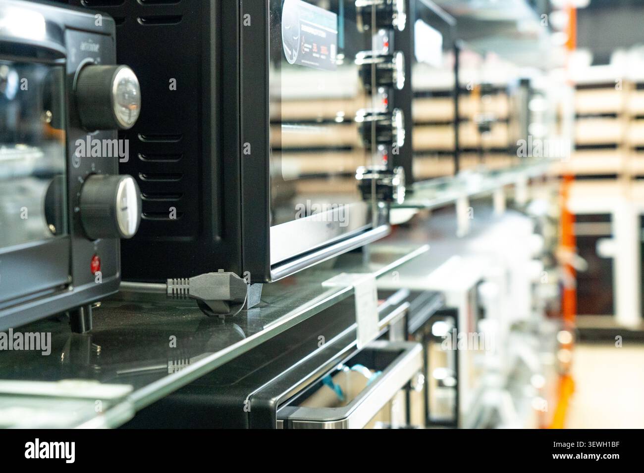 Collezione di moderni elettrodomestici da cucina in esposizione in un negozio al dettaglio, con vari forni, tostapane e attrezzature da cucina Foto Stock