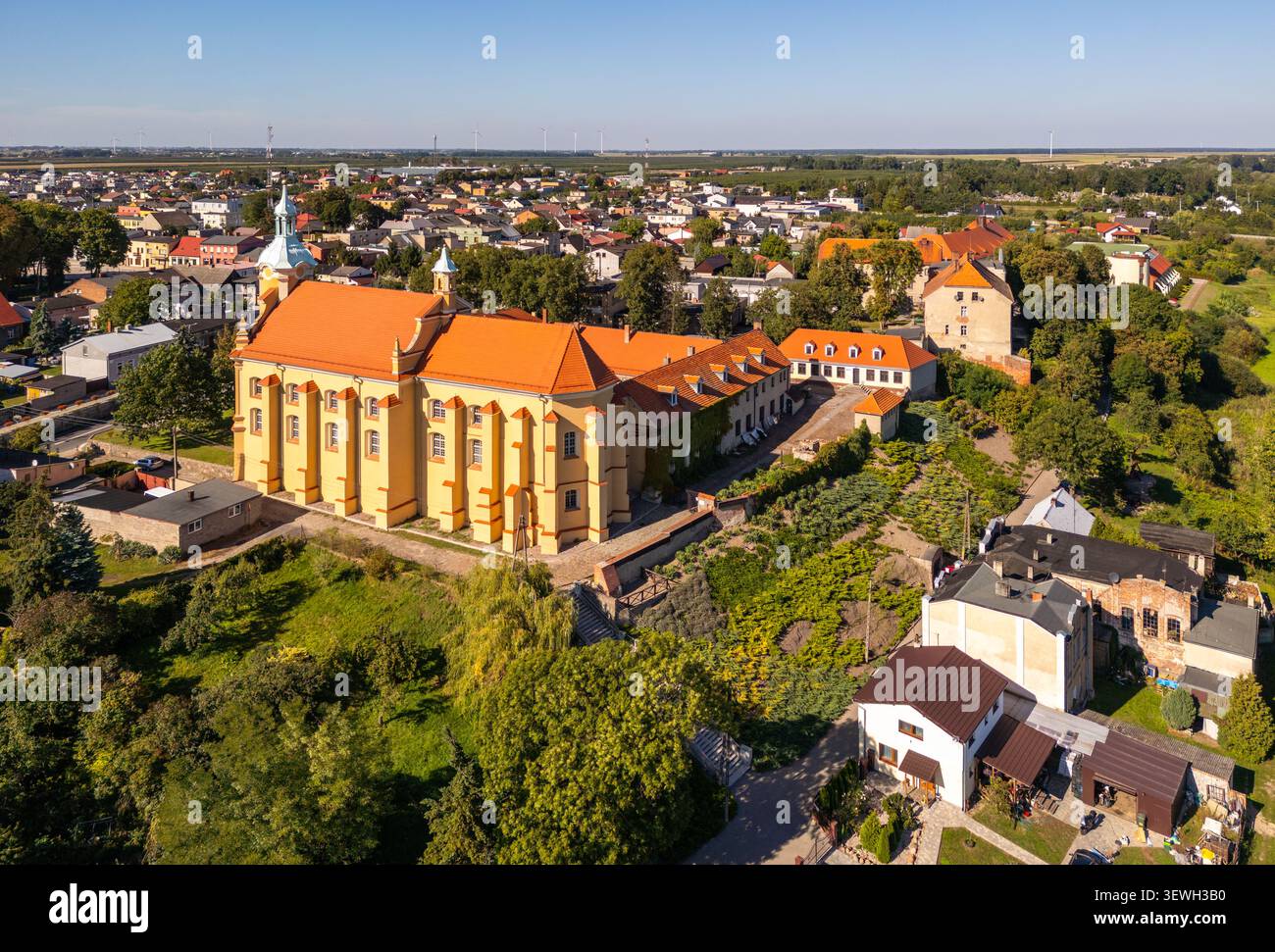 Vista aerea della chiesa storica con tetto arancione e mura gialle circondata dalla città di Pyzdry, Voivod, Polonia. Foto Stock