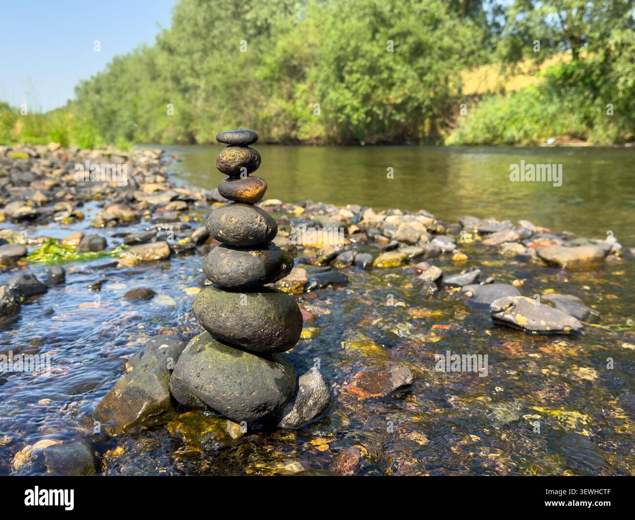 Una pila di pietre di equilibrio in un fiume che crea una scena di armonia Zen Foto Stock