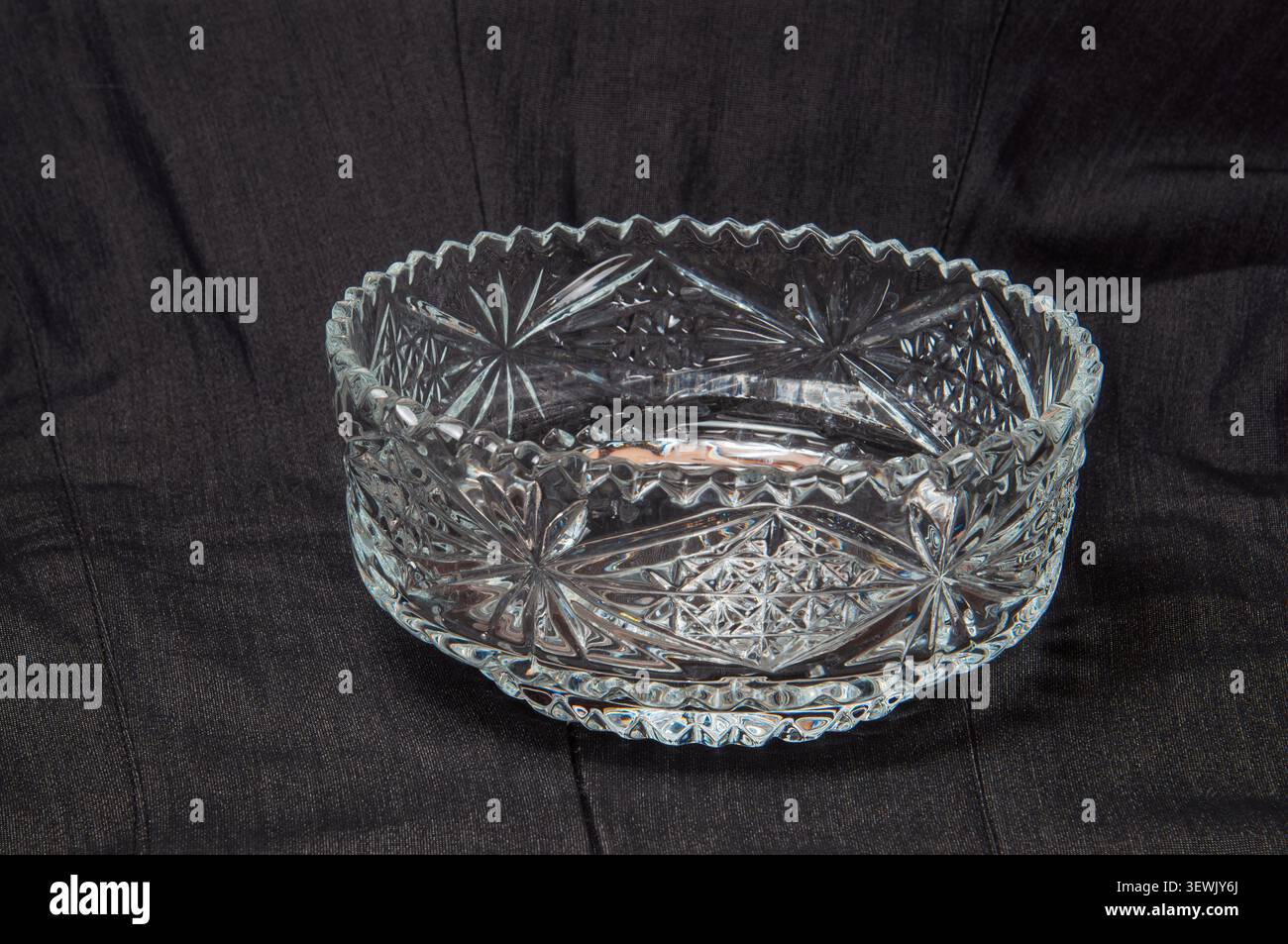Elegante ciotola in vetro tagliato con intricati motivi a raggiera e bordo sagomato Foto Stock