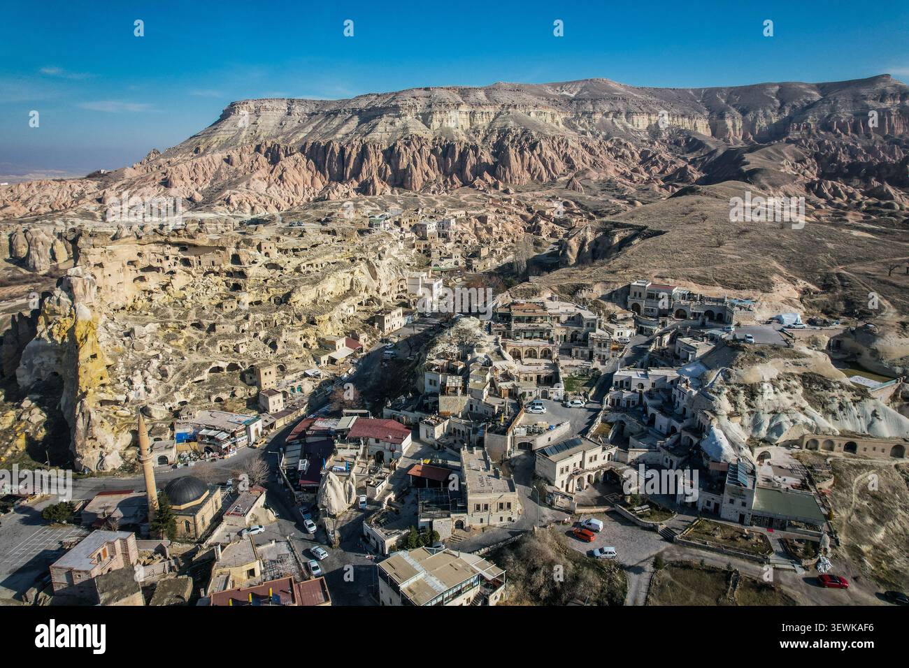 Una vista aerea grandangolare cattura la città di Uchisar annidata tra le formazioni rocciose uniche e i camini delle fate della Cappadocia, Turchia. Questo iconico Foto Stock