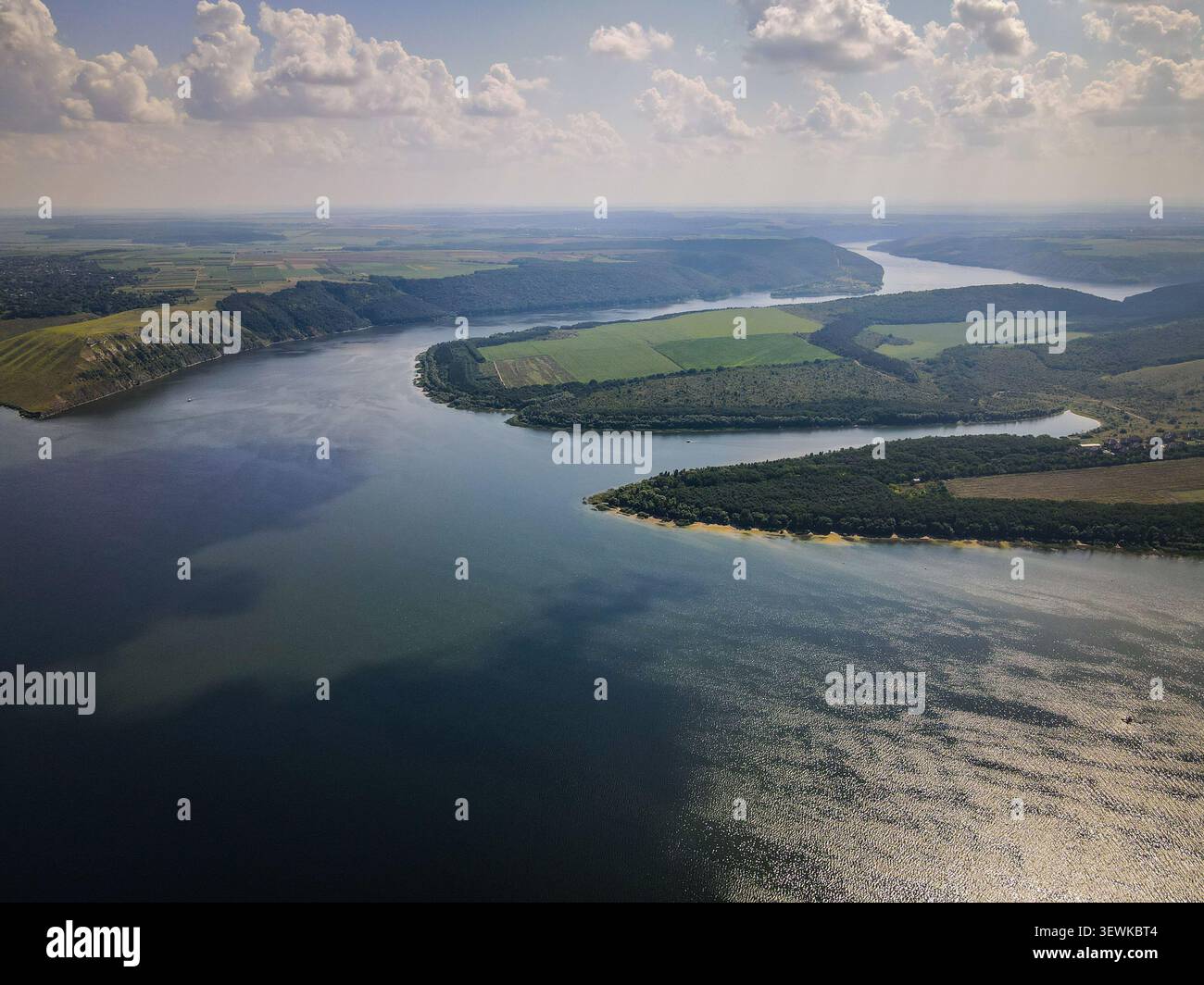 Uno scatto aereo cattura il fiume Dniester che si snoda attraverso un paesaggio di verdi colline, foreste e campi coltivati in Ucraina. Questa vista grandangolare Foto Stock
