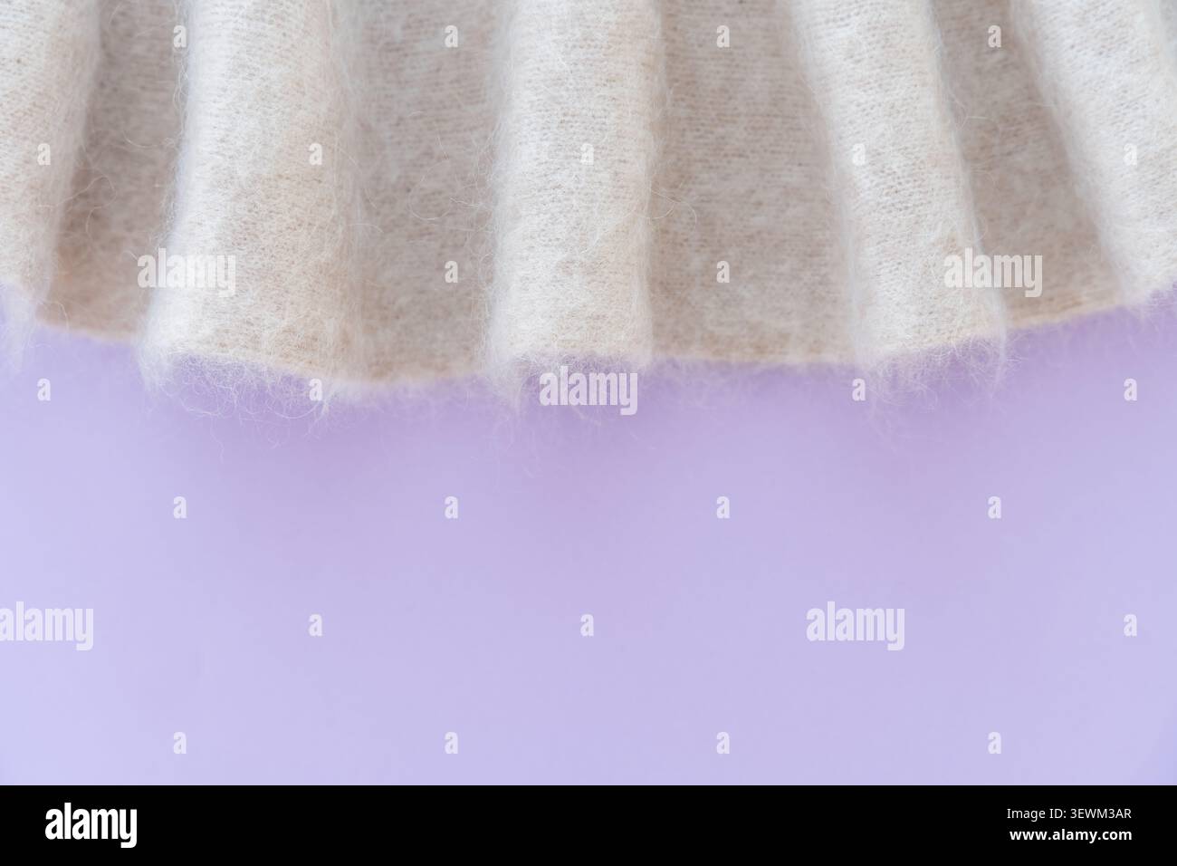 Morbido tessuto bianco di lana mohair con sfondo viola e pieghe. Foto Stock