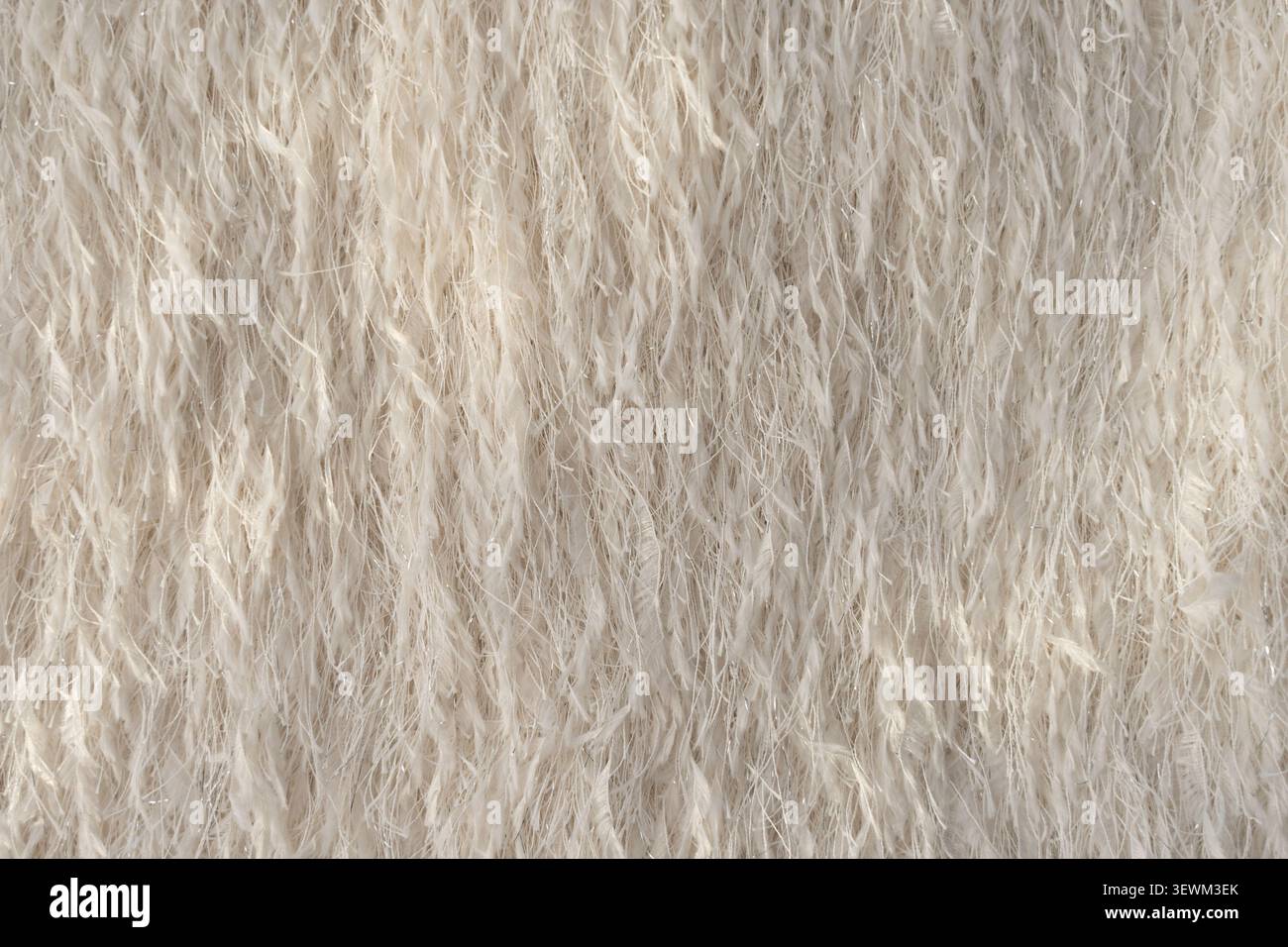 Primo piano di tessuti piuma con fili metallici scintillanti in tonalità beige. Foto Stock