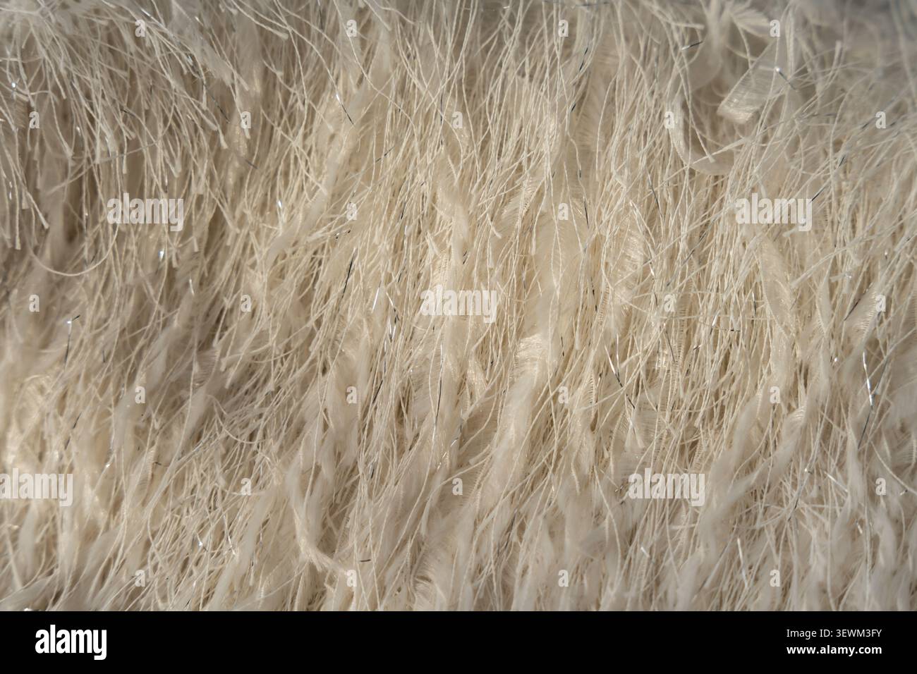 Primo piano di tessuti piuma con fili metallici scintillanti in tonalità beige Foto Stock