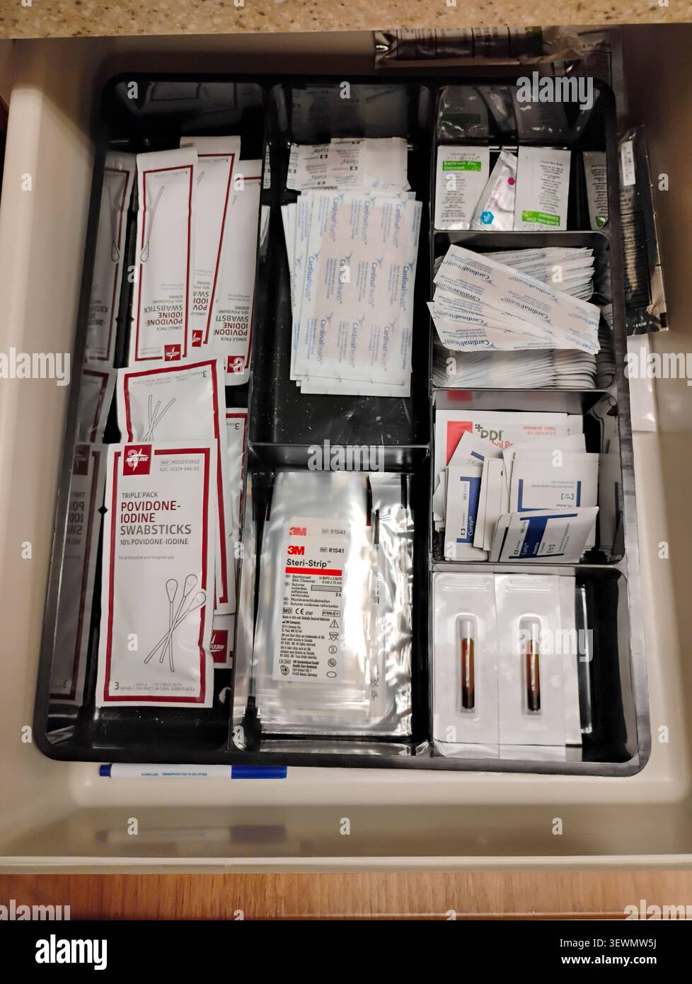 Un cassetto pieno di cerotti, tamponi e trattamenti delle ferite in uno studio medico. Foto Stock