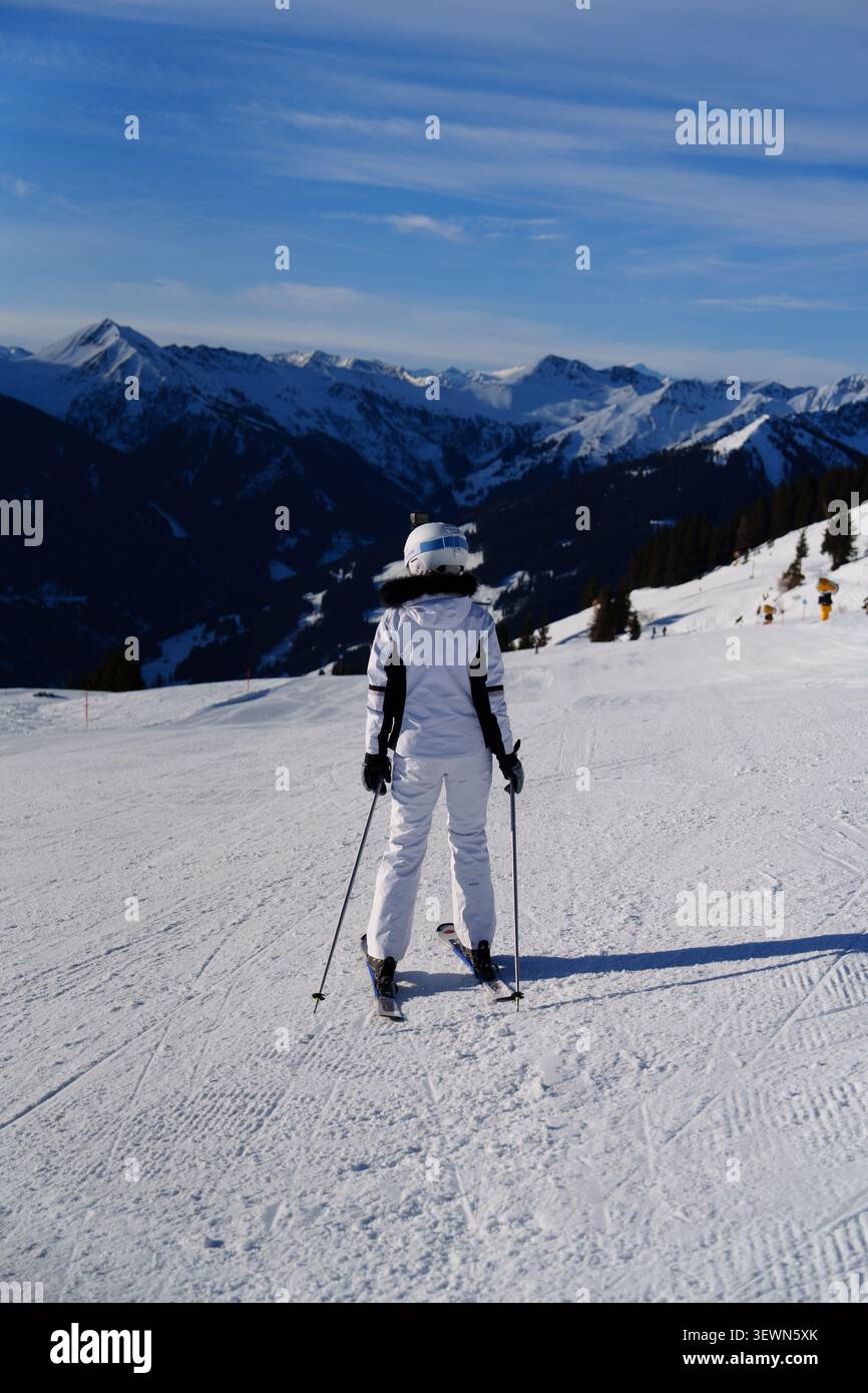 Sciatore in piedi su una pista ben curata a Saalbach, Austria, con vista panoramica sulle montagne Foto Stock