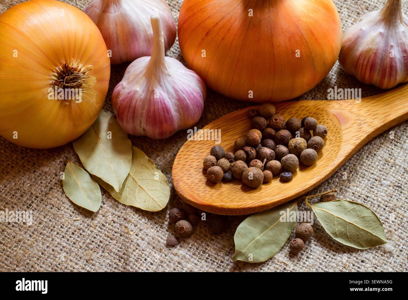 Allspezia, cipolla, aglio e alloro. Spezie e verdure primo piano. Foto Stock