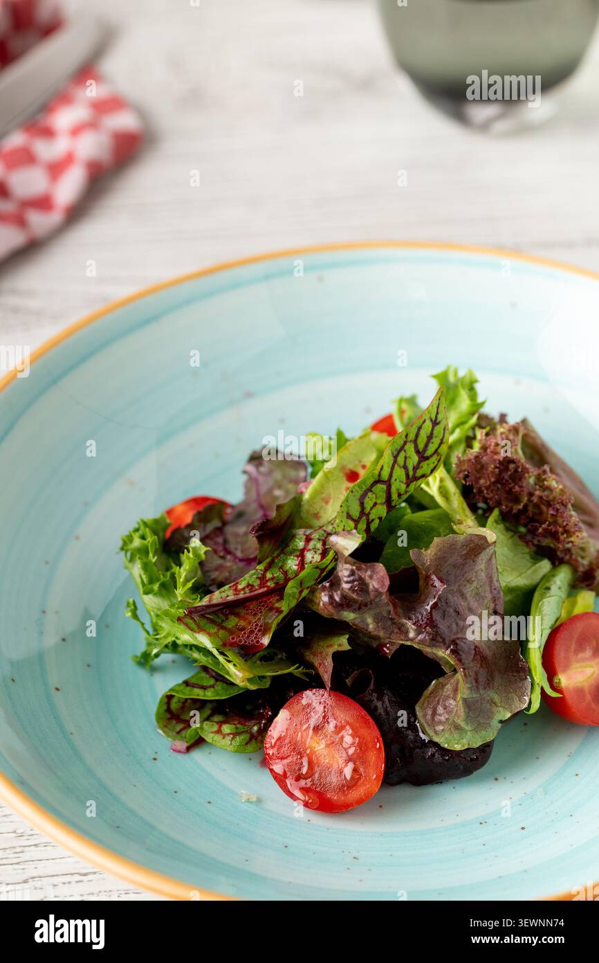 Insalata verde fresca servita in un elegante ristorante in stile mediterraneo Foto Stock