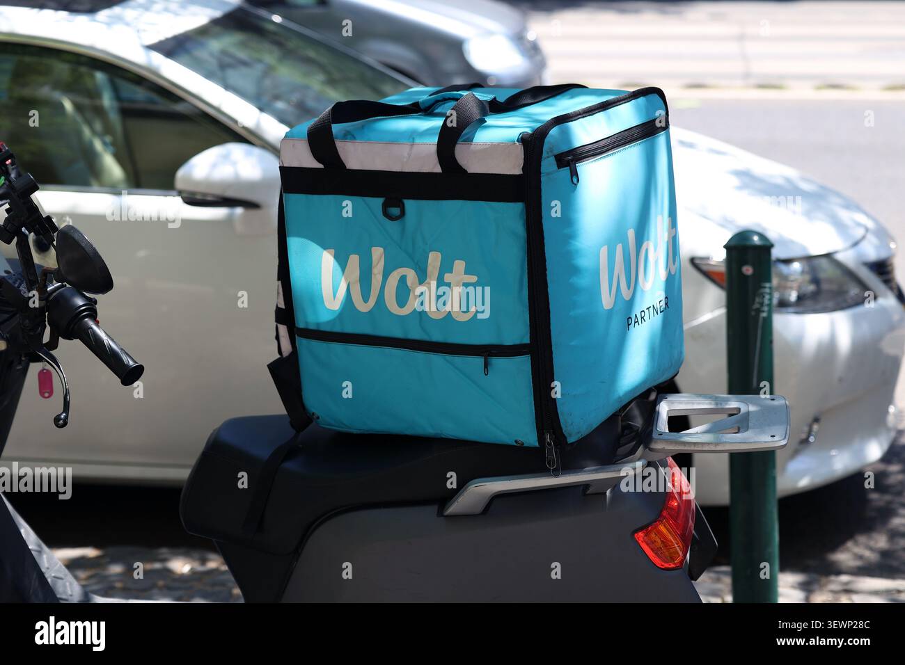 Borsa di consegna blu Wolt su un sedile di una moto parcheggiata sulla strada a Budapest, Ungheria Foto Stock