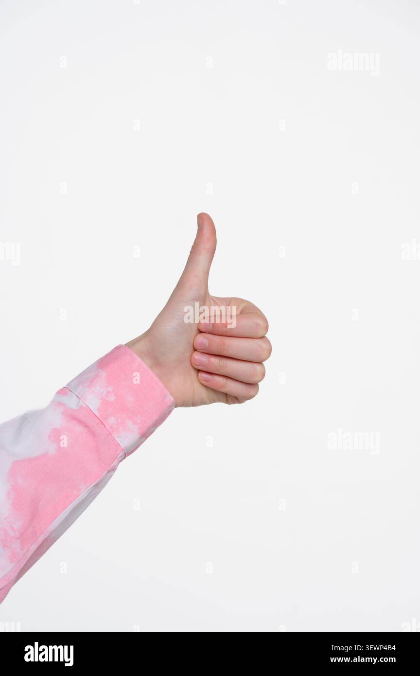 Primo piano di una mano che mostra il movimento dei pollici verso l'alto. Foto isolata in studio che rappresenta approvazione, successo, raccomandazione, soddisfazione e feedback positivo. Foto Stock