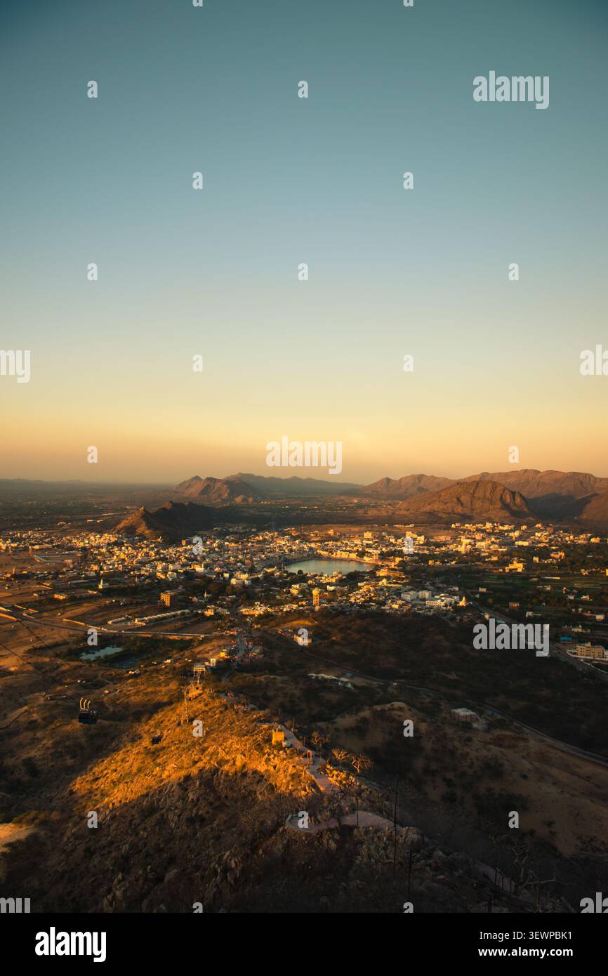 Vista aerea della città Santa di Pushkar, incastonata tra le colline Aravalli con il suo lago sacro che riflette la luce dorata del tramonto a Pushkar, Rajast Foto Stock
