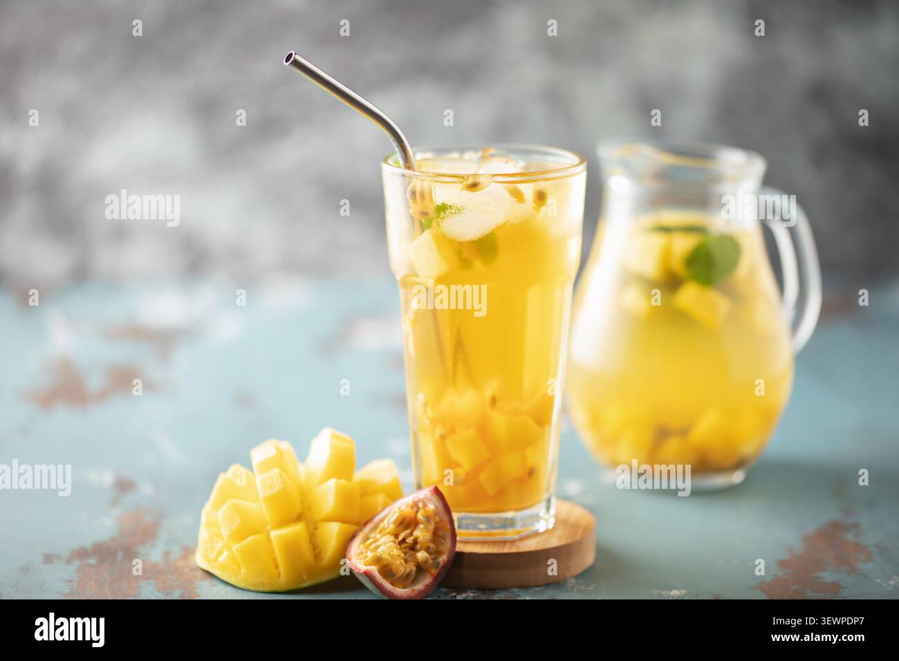 Tè freddo alla frutta con mango, frutto della passione e menta in una tazza di vetro sul tavolo. Foto Stock