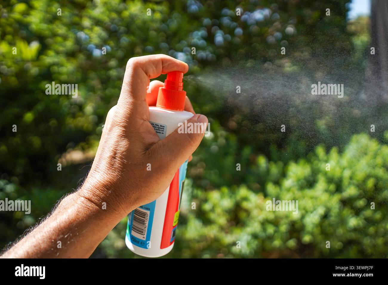 Mano utilizzando una bomboletta di aerosol in plastica, Foto Stock