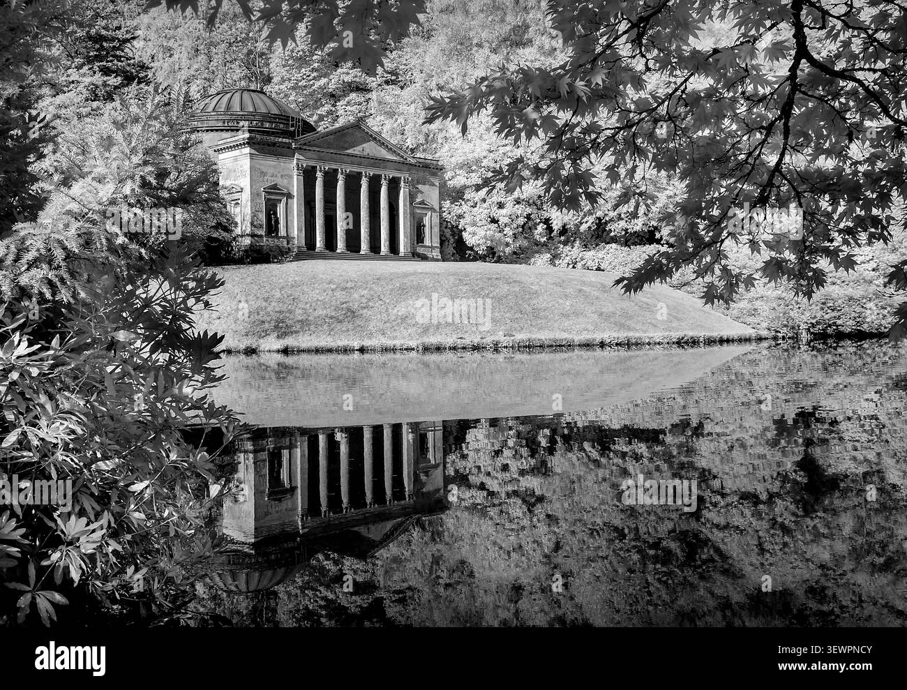 Vista monocromatica a infrarossi del Pantheon presso i Giardini Stourhead riflessa nell'acqua naturale incorniciata da alberi secolari in una tranquillità senza tempo Foto Stock