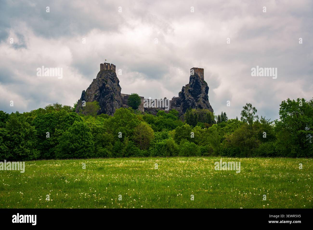 Vista panoramica delle iconiche rovine del castello di Trosky che si innalzano sopra le foreste e i prati nel bellissimo paradiso boemo, nella Repubblica Ceca, sotto il suggestivo scenario Foto Stock