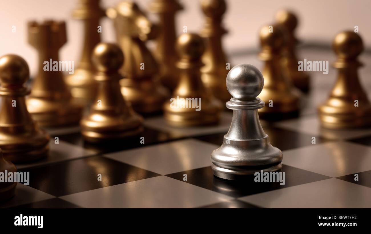 Scacchiera. Primo piano scacchi in argento e oro su una tavola classica. La mano sposta con attenzione un pezzo che simboleggia la decisione di pianificazione m Foto Stock