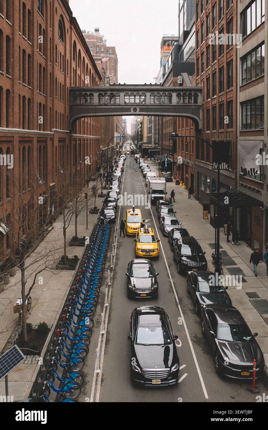 strada trafficata della città con edifici alti su entrambi i lati Foto Stock