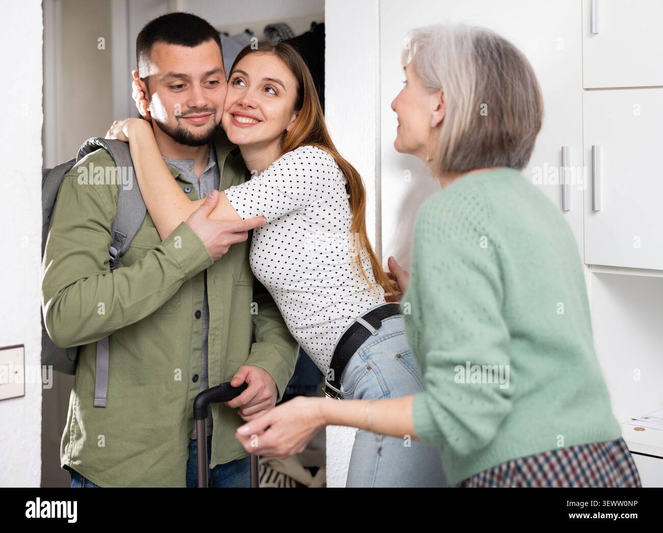 Donna e sua madre accolgono l'uomo a casa Foto Stock