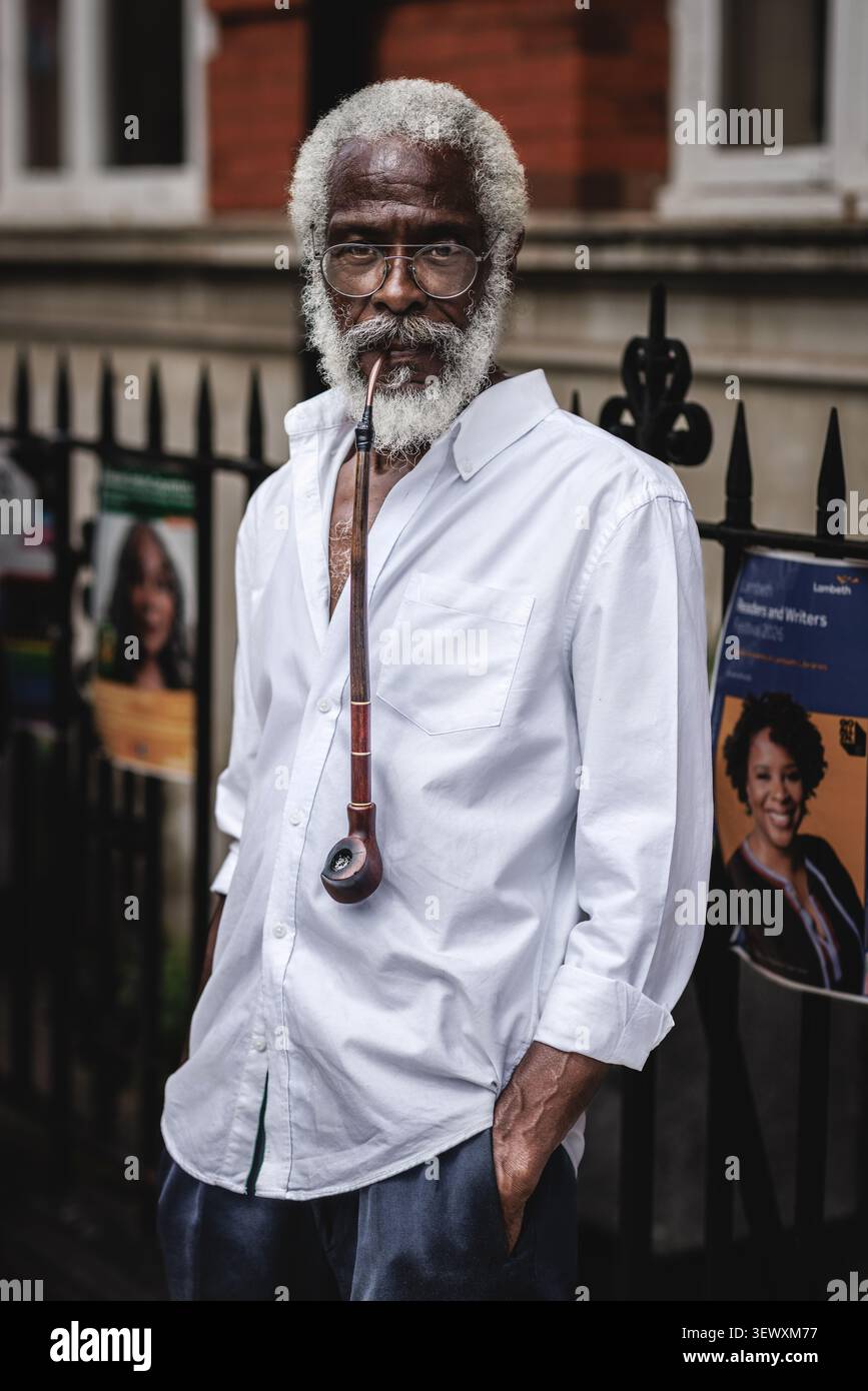 Ritratto di un fumatore di pipa insolito al Windrush Big Caribbean Lunch 2026 a Londra. Foto Stock